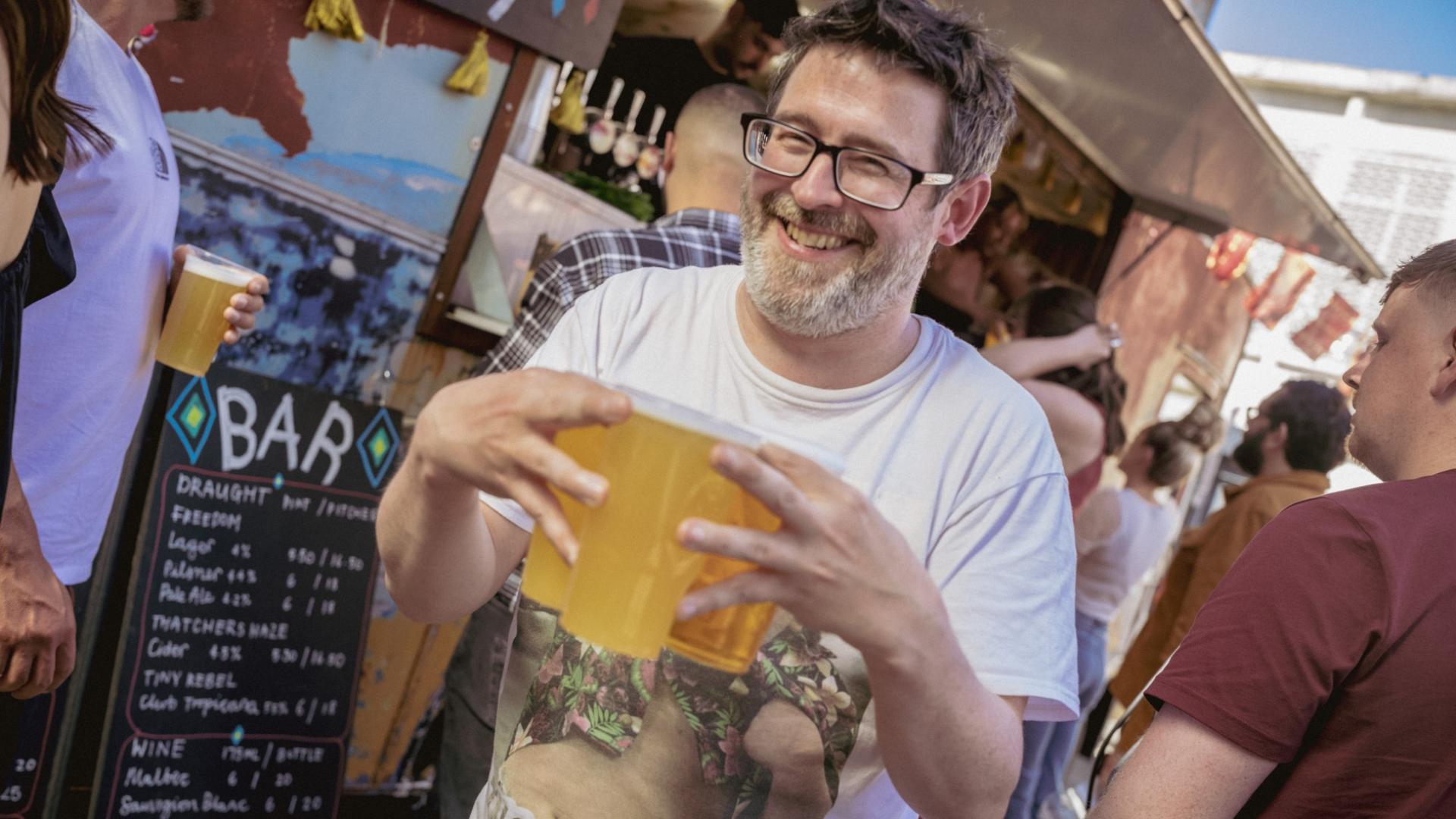 a guy holding 3 pints with a big green