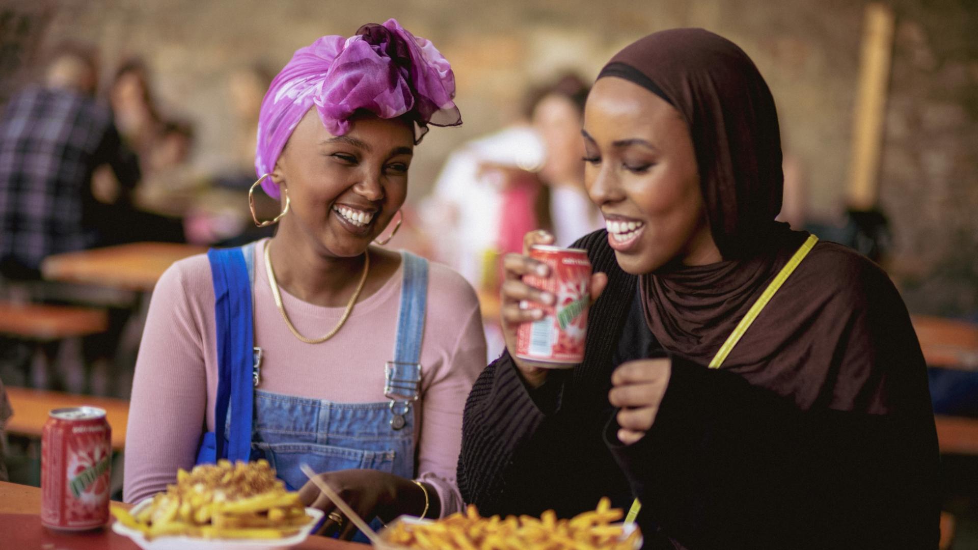 2 female friends enjoying they're food smiling