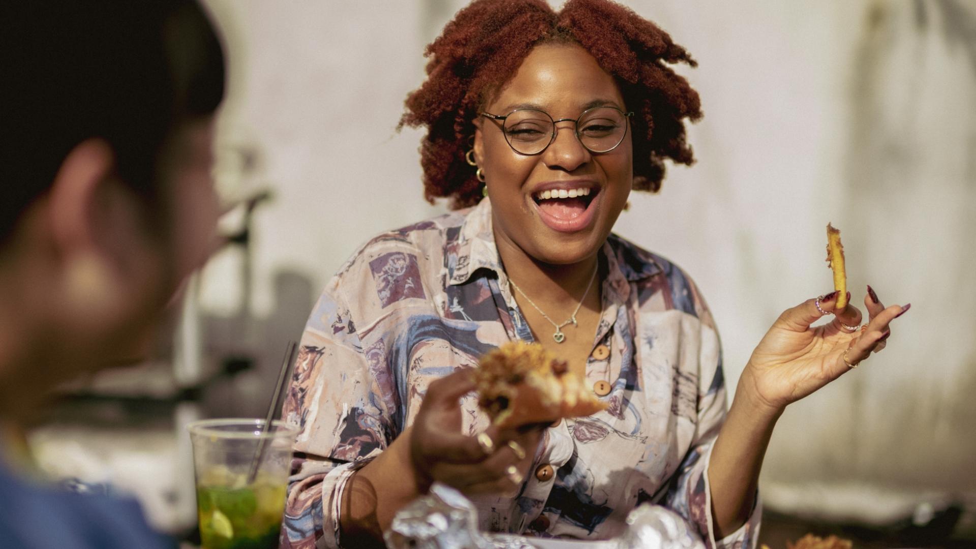 a woman holding a burger smiling