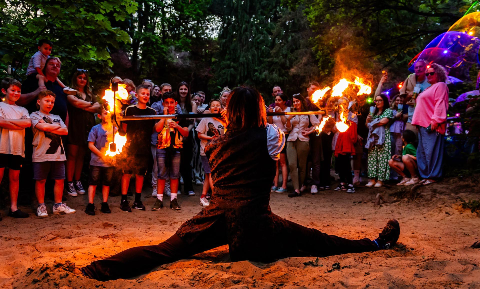 a man performing being watched by a group of kids